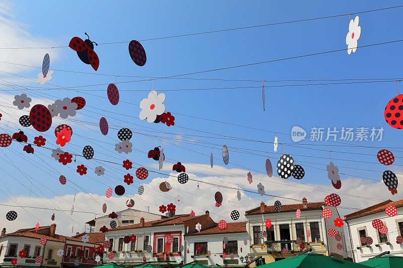 红-黑-白的花朵图案和点缀着瓢虫的色彩装饰悬挂在老巴扎Sheshi iliia广场上。korca -阿尔巴尼亚- 252